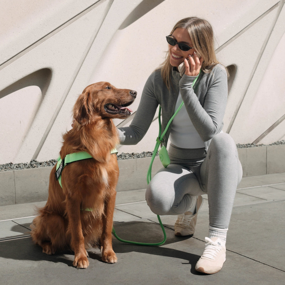 Dog owner wearing the Neon Green hands-free leash around the waist or across the body while walking a dog.