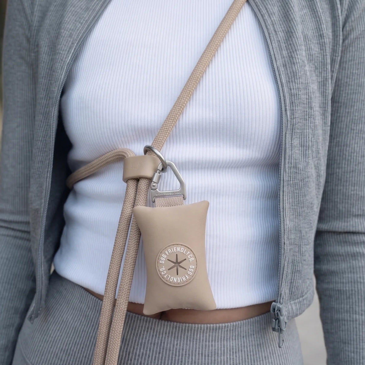 Close-up of the Premium Brown hands-free leash showing the waist strap, carabiner clip and attached accessory poop bag holder.