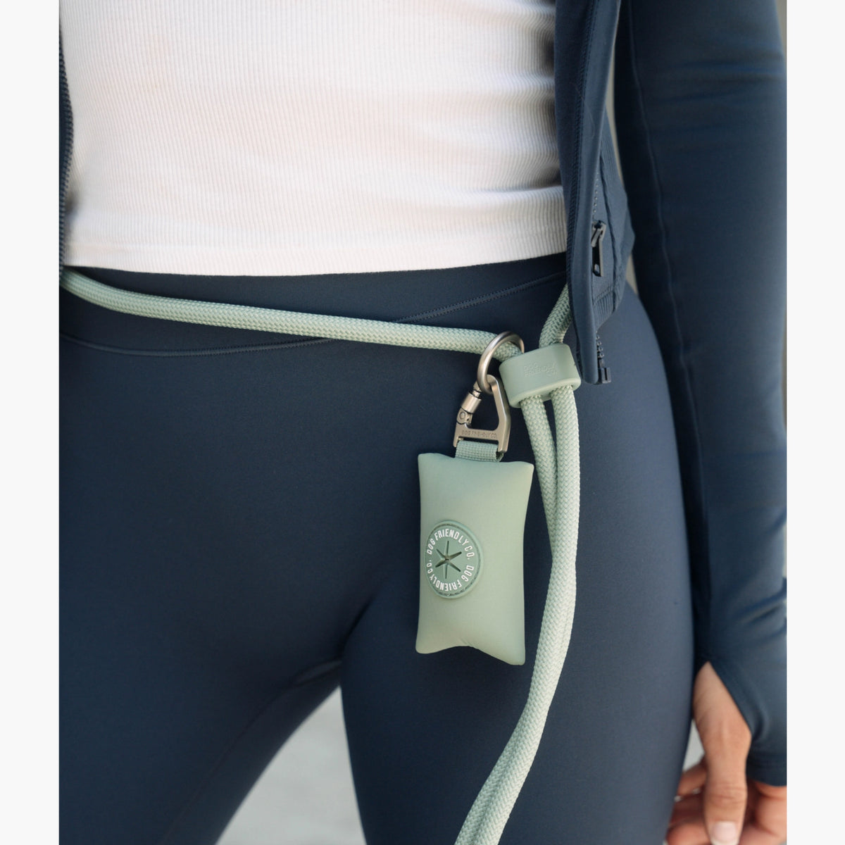 Premium Khaki hands-free dog leash worn around the waist, showing the adjustable strap, carabiner clip and attached accessory poop bag holder.