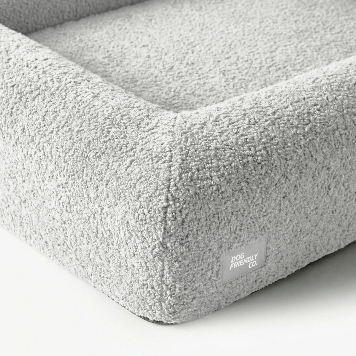 Grey Bouclé dog bed showing the soft textured cover and reinforced construction.